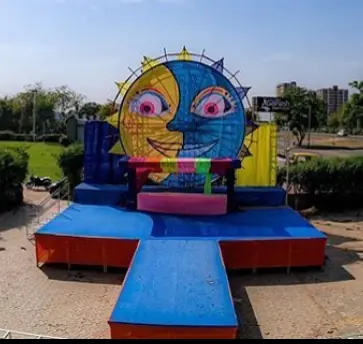 Colourful giant sun-face stage backdrop with a blue runway at Go Pagal Holi in Ahmedabad